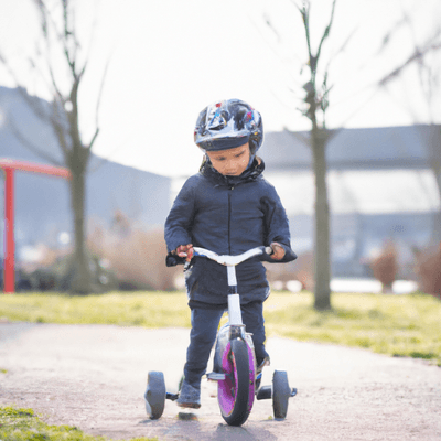 child riding a balance bike